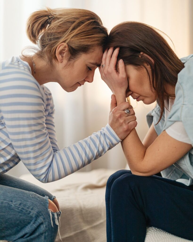 Two Women, one is very upset and the other is supporting her during an unplanned crisis pregnancy.