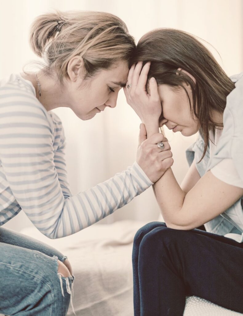 A women comforting another woman that obviously is in distress.